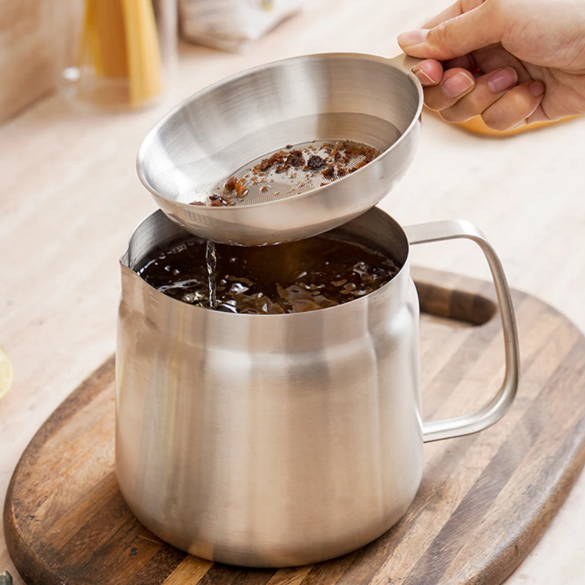 Stainless Steel Oil Pot Strainer being used on a wooden surface.